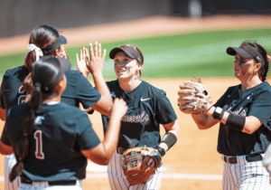 eku softball players high five in infield