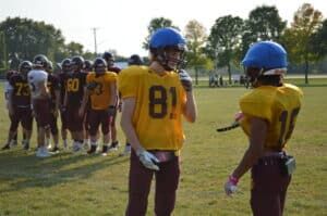 two football teammates talking at practice