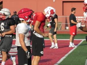 football player looking at gorout device at practice