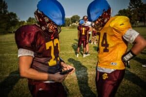 two stewartville football players looking at gorout device