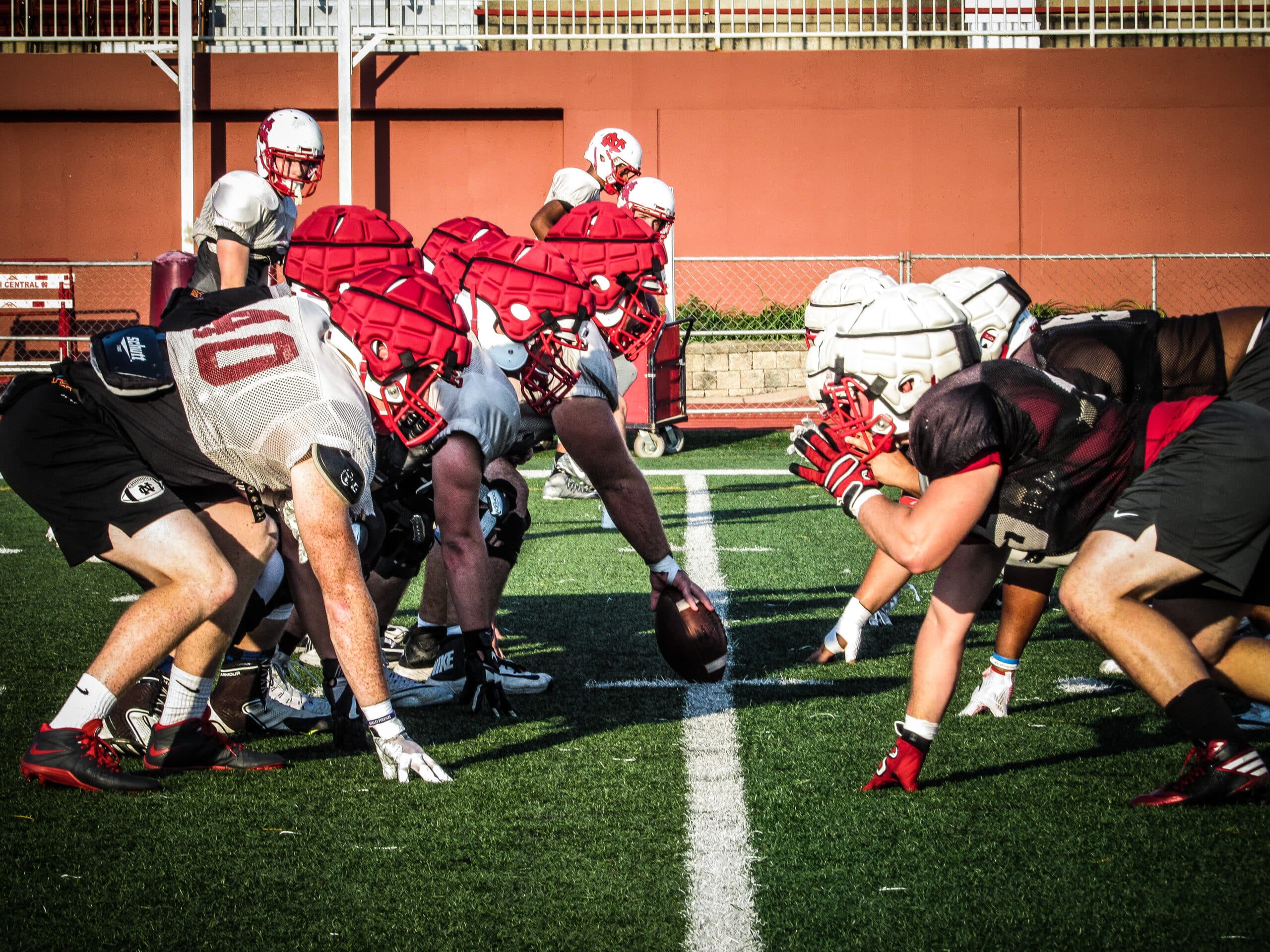 football offensive and defensive line lined up against each other in practice