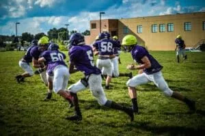 youth football players running at practice
