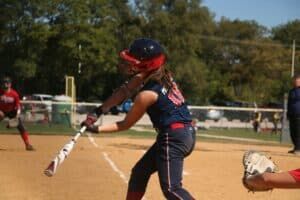 softball player swinging in game