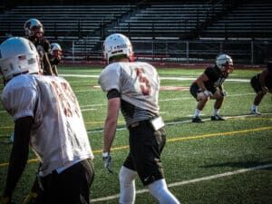 football receivers lined up at practice against football linebackers