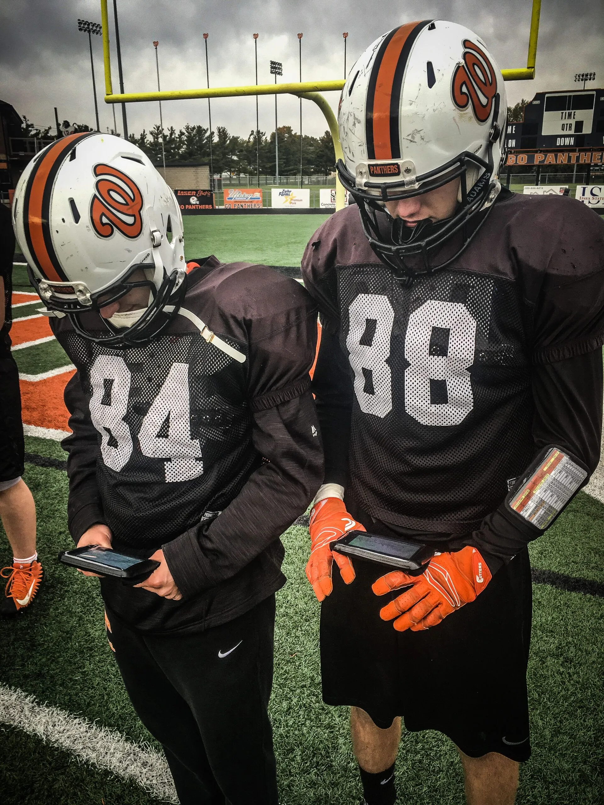 two football players looking at gorout practice device