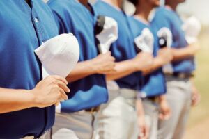baseball team lined up pre game with hats on chests