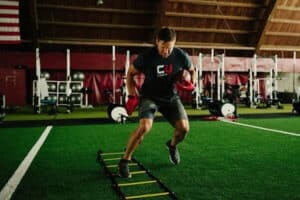 football player training on ladder at indoor facility