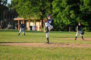 youth baseball pitcher in yankees uniform pitching in game
