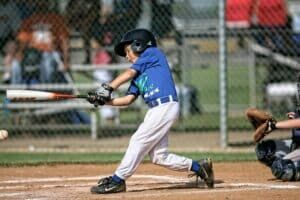 youth baseball player swinging in game