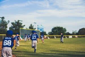 youth baseball team running in outfield