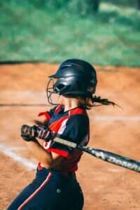youth softball player batting in game