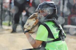 youth softball catcher in game taking pitch call