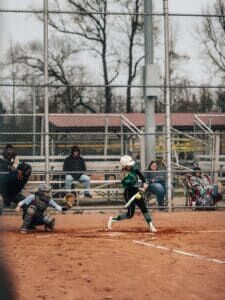 softball player hitting ball in game