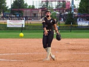 softball pitcher in face mask throwing pitch