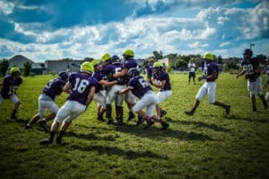 youth football players tackling each other