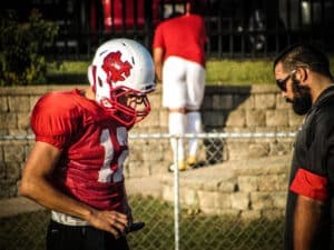 football coach working with quarterback to use gorout device