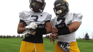 two football players using GoRout wristbands at practice
