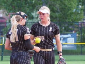 softball pitcher talking with catcher using electronic pitch calling system