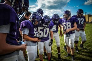 youth football team looking at play call on gorout device