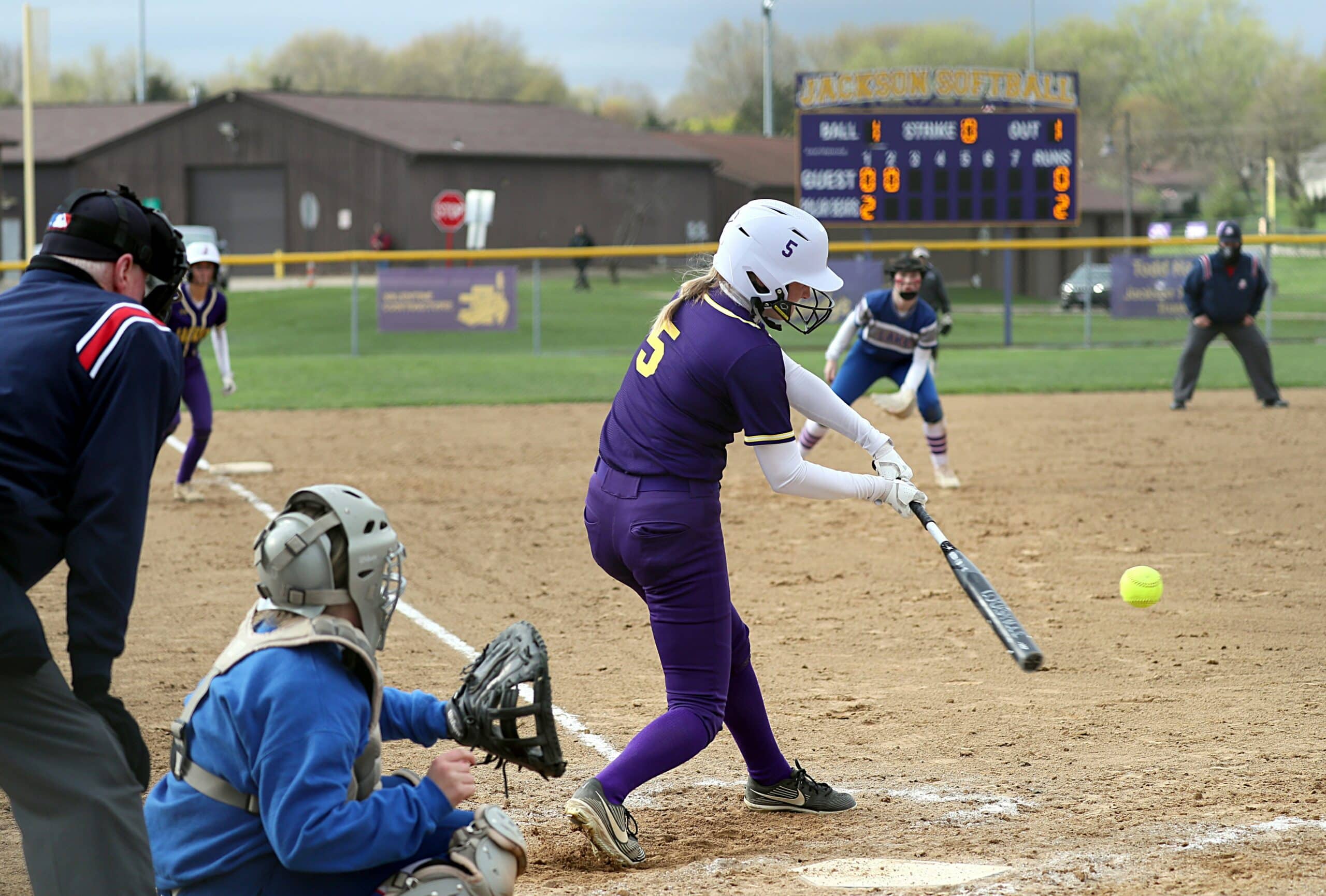 softball player hitting ball in game