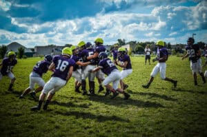 youth football players tackling each other