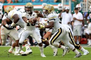 Georgia Tech QB holds the ball out as he reads the defense and decides whether to give it to the RB or keep it and run himself