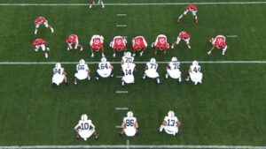 Offensive set featuring the QB under center and three running backs in a horizontal line behind him