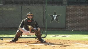 Collegiate catcher working on receiving drills in front of a net