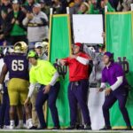 Decoy or "dummy" signal callers on a college football sideline wearing assorted colors which determine the correct sign