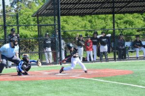 Youth batter taking a swing and making solid contact with a pitch