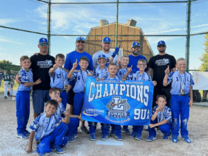 Travel baseball team celebrating a tournament win by taking a photo with a banner and trophies