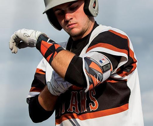 Baseball base runner strapping on arm guard