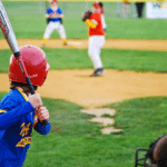 youth baseball pitcher prepares to throw to batter in game