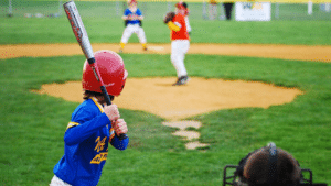 youth baseball pitcher prepares to throw to batter in game