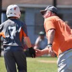 baseball coach high-fiving player rounding base