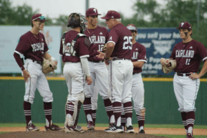 baseball coach at mound meeting with players