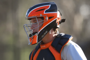 baseball catcher in orange and black gear