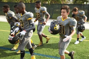 youth football team running out onto field