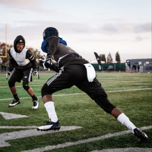 football receiver and defensive back practicing with protective headgear