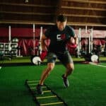 football player training on ladder at indoor facility