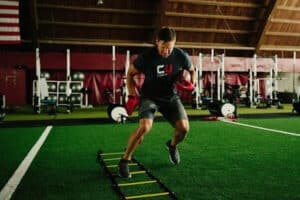 football player training on ladder at indoor facility