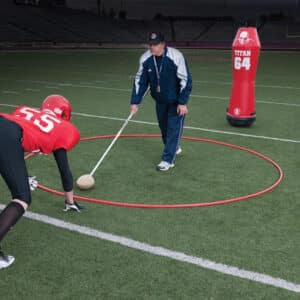 football coach training defensive player in agility ring