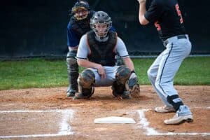 baseball catcher behind home plate with two fingers down giving pitch call