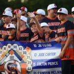 travel baseball team holding banner on field