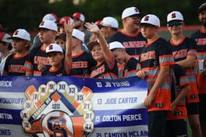 travel baseball team holding banner on field