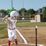 t-ball player hitting ball off of tee in game