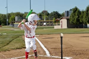 t-ball player hitting ball off of tee in game