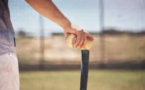 baseball coach putting balls on tee