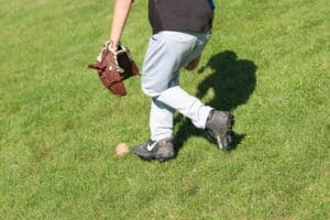youth baseball player fielding ball in outfield