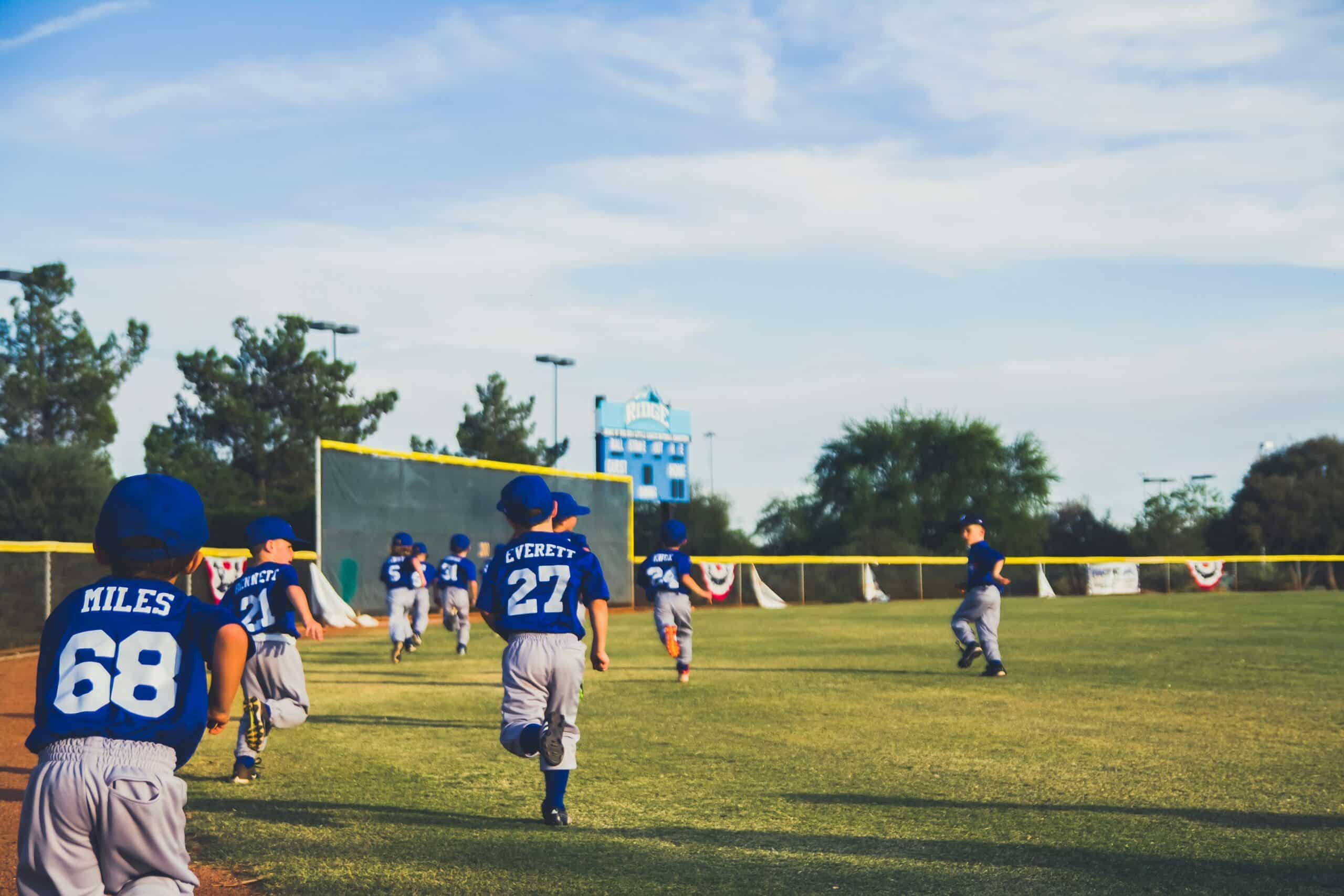 youth baseball team running in outfield